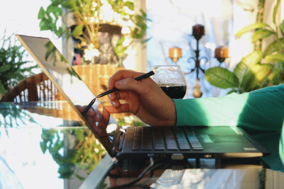 Individual using a stylus on a laptop screen